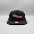 Black cap with 'Mad Hatter Company' logo on a white surface